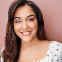 Close-up portrait of a smiling female student named Gabriela wearing floral top.